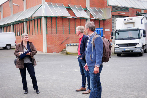 Meike Rohkemper vom WILA Bonn macht einen Potenzialcheck auf einem Gelände eines Logistik-Unternehmens. Sie ist gemeinsam mit zwei Mitarbeitenden auf dem Gelände zu sehen mit einem Klemmbrett in der Hand. Foto: (c) WILA Bonn