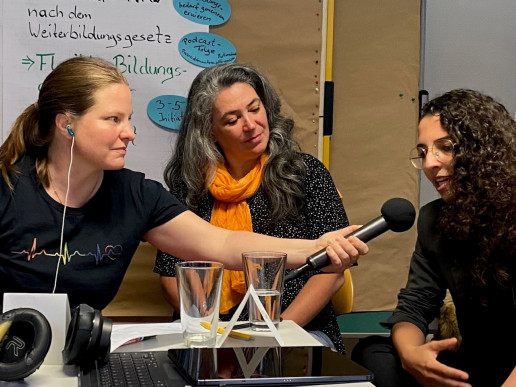 Aufnahme des Podcast im Projekt Idee und wie. Monika Konigorski interviewt eine ehrenamtliche Initiative und h&auml;lt daf&uuml;r einer Dame ein Mikrofon hin.