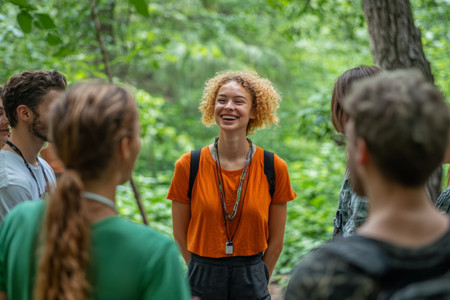 Dieses Bild zeigt eine junge Frau mit einer Seminargruppe im Wald. Foto: © ©-Michael – stock.adobe_.com