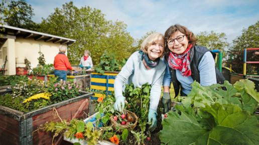 Zwei Frauen gärtnern gemeinsam und lächeln in die Kamera. Foto: © Stadt Bonn