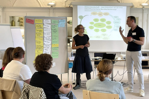 Das Bild zeigt eine Schulung von Akteur*innen im Bereich Berufsorientierung mit Iken Draeger vom WILA Bonn. Sie steht vor einer Pinnwand mit einer Präsentation im Hintergrund. Foto: (c) Netzwerk Grüne Arbeitswelt